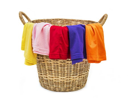 Colorful clothes in a laundry wooden basket on white backgroundの写真素材