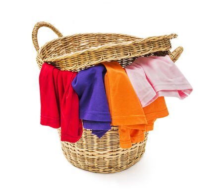 Clothes in a laundry wooden basket on white backgroundの写真素材