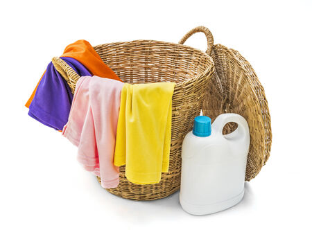 Colorful clothes in a laundry wooden basket on white backgroundの写真素材