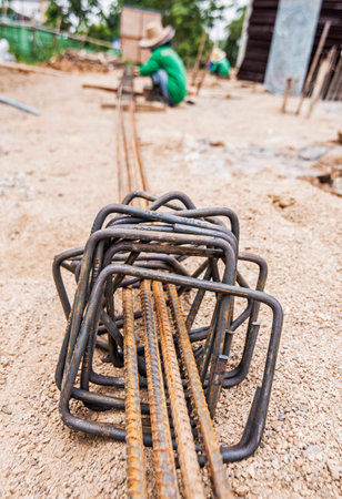 Asian women construction worker installing binding steel wires to reinforcement steel bars in construction site  の写真素材