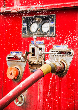 wasting water - water leaking from a connector of hose from fire truck  の写真素材