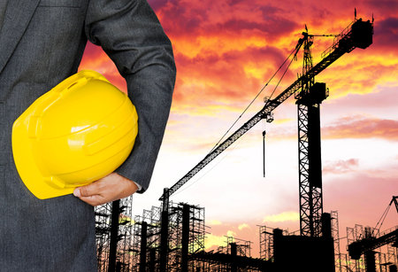 Worker or engineer holding yellow helmet for workers security in construction site の写真素材