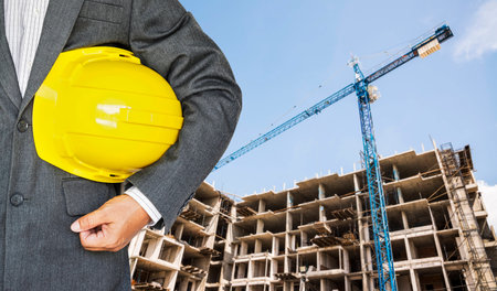Worker or engineer holding yellow helmet for workers security in construction site