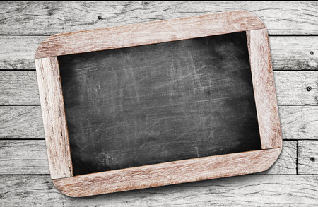 Small black chalkboard on wood backgroundの写真素材
