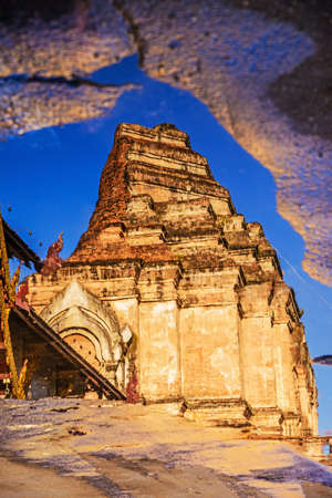 Ancient pagoda at Wat Chedi Luang temple on water reflection, Chiang Mai, Thailand の写真素材