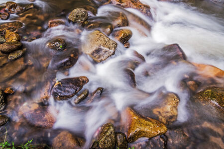 Water flows over steep rocks in a stream. の写真素材