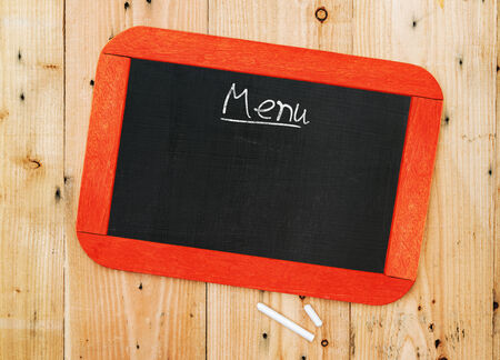 Menu blackboard lying on wood backgroundの写真素材