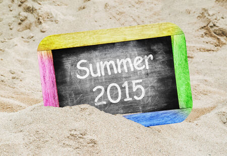 Summer 2015 written in a chalkboard on a beachの写真素材