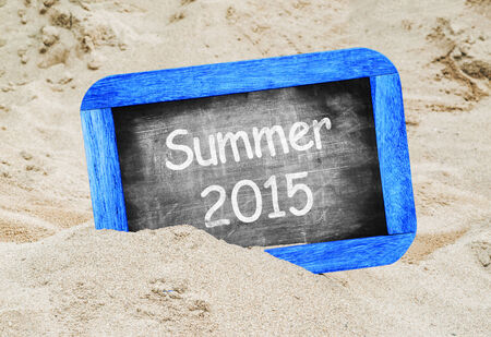 Summer 2015 written in a chalkboard on a beachの写真素材