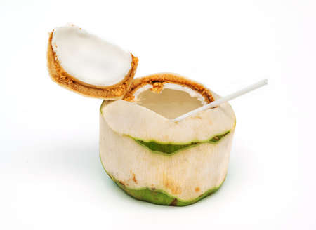 Coconut with drinking straw on white background.