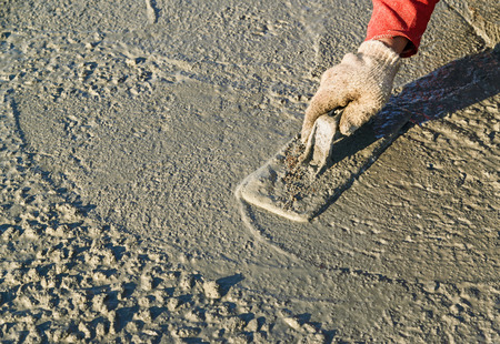 Construction worker spreading wet poured concreteの写真素材