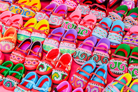 Hand-made baby shoes on red background.の写真素材