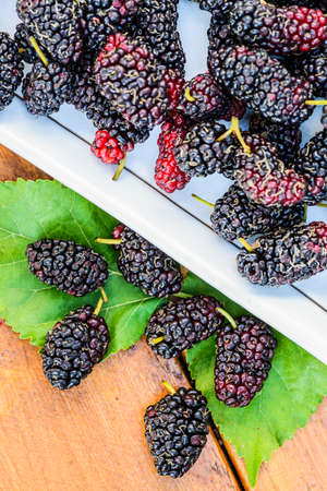 Group of mulberries isolated on wood background.の写真素材
