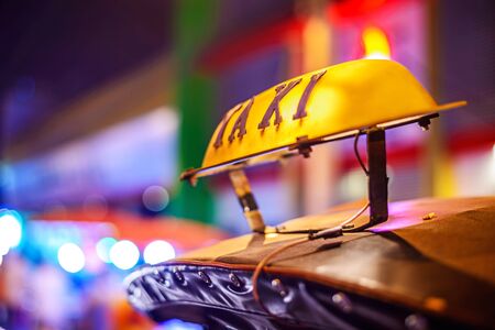 Thai Taxi (Tuk Tuk) sign with defocused lights blur , Chiang Mai, Thailand.の写真素材