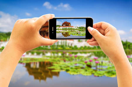 Smart phone taking photo of Thai architecture in the Lanna style , Royal Pavilion (Ho Kum Luang),...