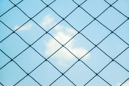 Seamless mesh fence in football stadium on blue sky.の写真素材