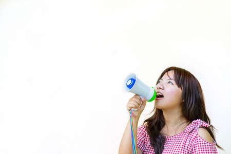 Young asian woman holding megaphone and shouting.の写真素材
