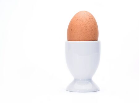 Brown egg on stand cup isolate on white.の写真素材