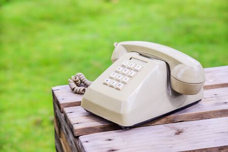 Retro rotary telephone on wood table isolated grass backgroundの写真素材