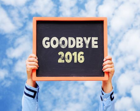 Hands holding blackboard with Goodbye 2016 year.の写真素材
