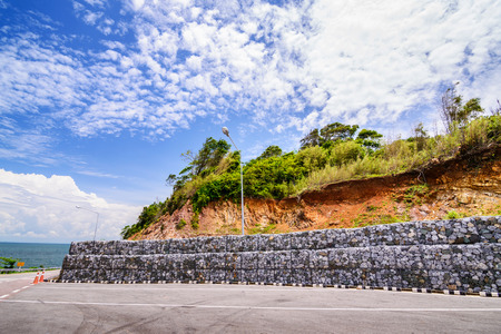 Gabion wall made of stones in the steel mesh, used as a fence on a slope.の写真素材