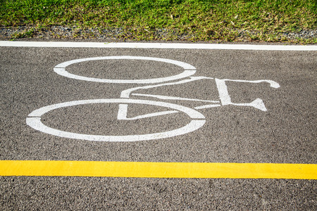 Bicycle sign on bicycle lane in morning sunshine. The main focus is at the symbol.
