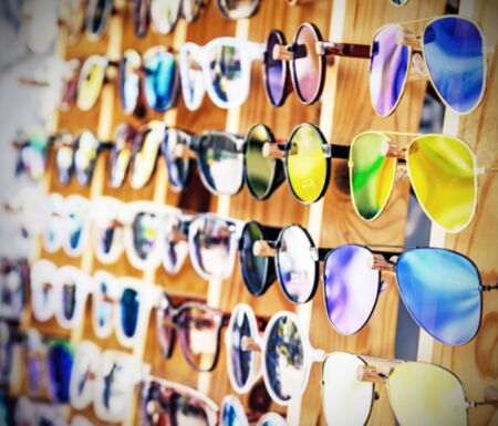 Blurred sunglasses on wood table, use for background. Vintage filter style.の写真素材