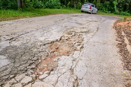 Gravel on the dirt road, which cracks due to water erosion and land subsidence.の写真素材