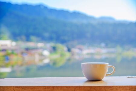Empty coffee cup on wood table with blur background.の写真素材