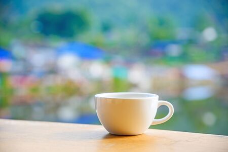 Empty coffee cup on wood table with blur background.の写真素材