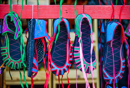 Many pairs of chinese cloth shoes hang on a shelf background, selective focusの写真素材
