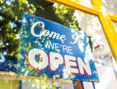 Open sign broad hanging on the door through the glass at coffee shopの写真素材