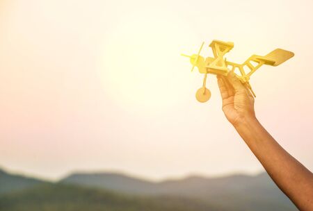 Hand holding an airplane, Toy airplane in hand. concept for dreams and travel.の写真素材