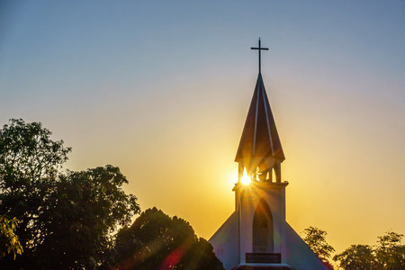 The silhouette of the cross and church bell tower in sunriseの写真素材