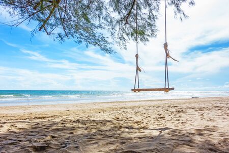 Wooden swing hanging from a tree on the beach , Chao Lao Beach, Chanthaburi in Thailand.の写真素材