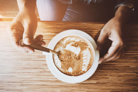 Woman and a cup of coffee with vintage film filter effectの写真素材