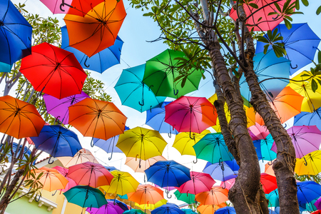 Multi-colored umbrellas background. Colorful umbrellas floating above the street. Street decoration.の写真素材