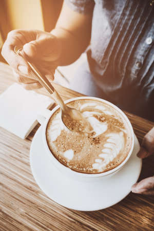 Woman and a cup of coffee with vintage film filter effectの写真素材