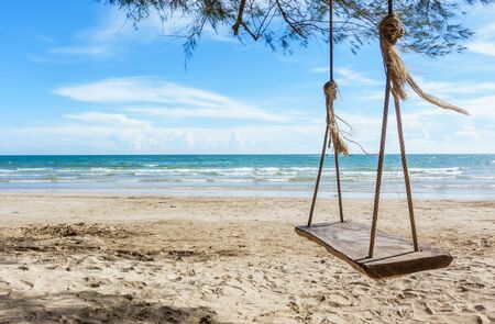 Wooden swing hanging from a tree on the beach , Chao Lao Beach, Chanthaburi in Thailand.の写真素材