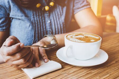 Woman and a cup of coffee with vintage film filter effectの写真素材