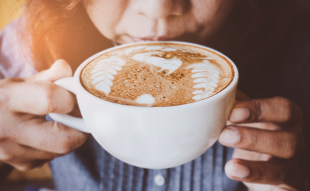Woman and a cup of coffee with vintage film filter effectの写真素材