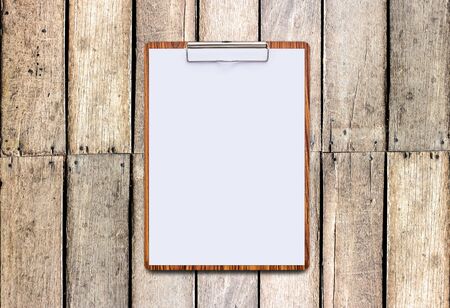 Clipboard with white sheet on wooden background, mock up for word.の写真素材
