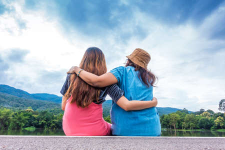 Mother and daughter hugging each other outdoorsの写真素材