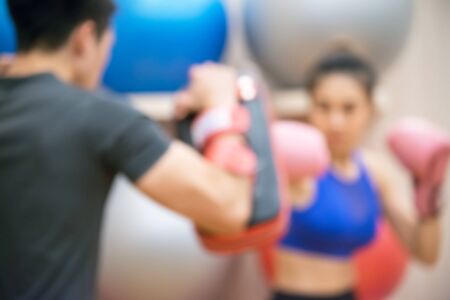 Blurred Female practicing boxing. Fit woman and her trainer boxing indoors the gym.の写真素材