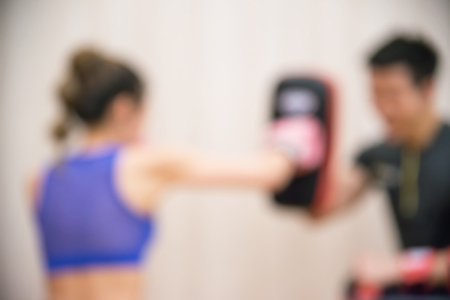Blurred Female practicing boxing. Fit woman and her trainer boxing indoors the gym.の写真素材