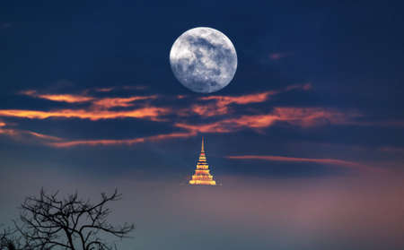 Supermoon. Full moon with a deep blue sky, misty and pagoda at night. View of a big moon, Moonrise in Thailandの写真素材
