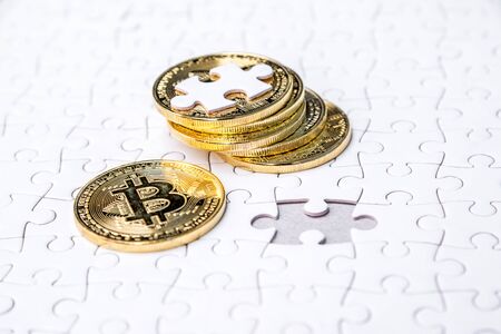 Gold bitcoin on white jigsaw or puzzle, cryptocurrency. Missing jigsaw puzzle pieces. Business solution concept, Key for success concept. Completing finance concept.の写真素材