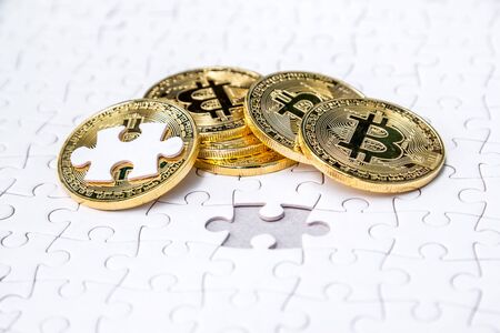 Gold bitcoin on white jigsaw or puzzle, cryptocurrency. Missing jigsaw puzzle pieces. Business solution concept, Key for success concept. Completing finance concept.の写真素材