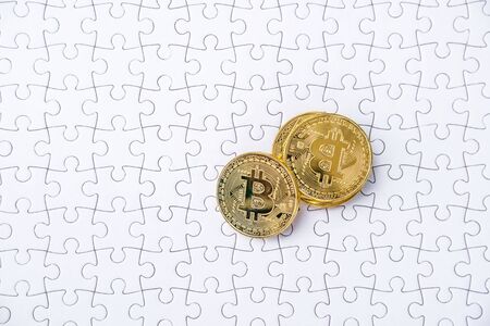Gold bitcoin on white jigsaw or puzzle, cryptocurrency. Missing jigsaw puzzle pieces. Business solution concept, Key for success concept. Completing finance concept.の写真素材