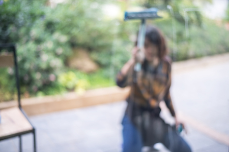 Blurred woman cleaning a mirror. Blurred out details of window cleaning.